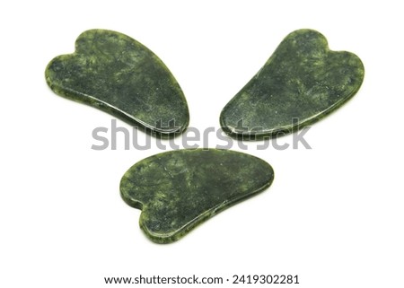 Gua Sha massager from various perspectives isolated on white background. Green jade stone for face and body care. Copy space. Top view.