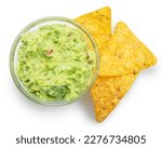 Guacamole bowl and corn chips near it on white background. Top view. File contains clipping path.