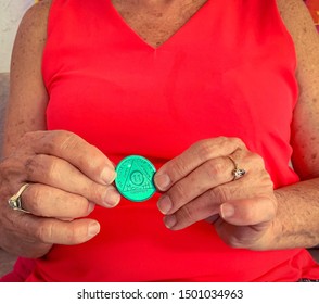 Guadalajara, Jalisco - September 10 2019: Senior Woman Proudly Holds AA Alcoholics Anonymous 11 Month Sobriety Chip, Awarded For Abstaining From Alcohol Or Other Substances. Addiction Recover 