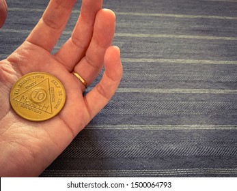 Guadalajara, Jalisco - September 9 2019: Female Hand Holds AA Alcoholics Anonymous 10 Months Sobriety Chip, Awarded For Abstaining From Alcohol Or Other Substances. Addiction Recovery Hope Success 