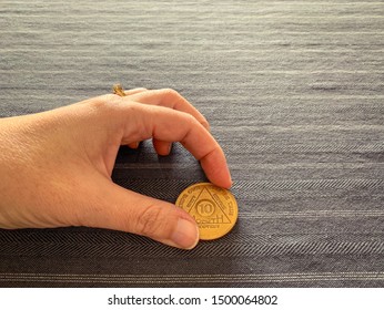 Guadalajara, Jalisco - September 9 2019: Female Hand Holds AA Alcoholics Anonymous 10 Months Sobriety Chip, Awarded For Abstaining From Alcohol Or Other Substances. Addiction Recovery Hope Success 