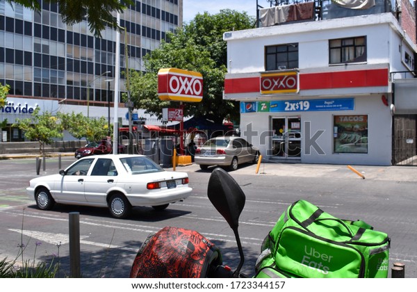 Guadalajara, Mexico -
March 03 2020: Uber eats bag, Oxxo convenience store in the
background. White Tsuru
car