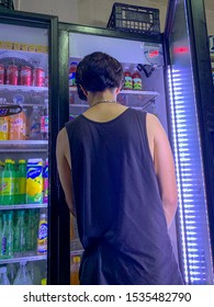 Guadalajara, Mexico - October 19 2019: Young  Male Wearing Black Top Stands By Soft Drinks Fridge At A Small Neighborhood Store