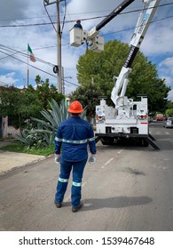 Guadalajara, Mexico - October 22 2019: CFE Male Electrical Company Workers In Uniform Attend To An Electrical Post Fire Incident. Outdoors Street Accident Scene. Blue Collar Workers 