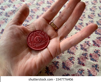 Guadalajara, Mexico - October 29 2019: Hand Holding AA Alcoholics Anonymous Sobriety Chip Awarded For Abstaining From Alcohol Or Other Substances For 5 Months