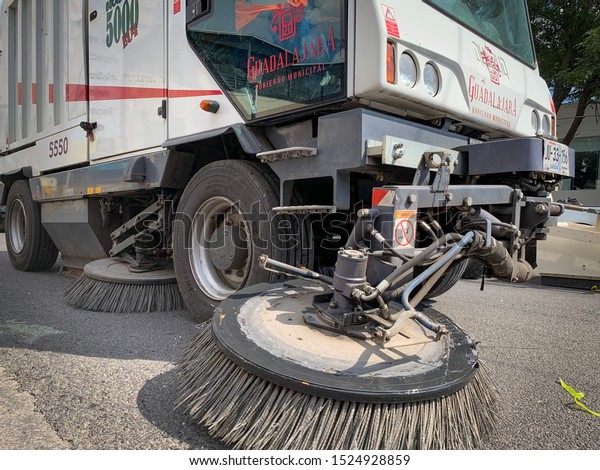 Guadalajara,\
Mexico - October 6 2019: Sweeper truck cleans the street after\
parade. Municipal government of\
Guadalajara