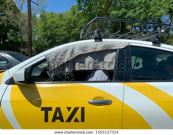 Guadalajara, Mexico - September\
15 2019: Yellow and white mexican taxi in Guadalajara in the\
summer