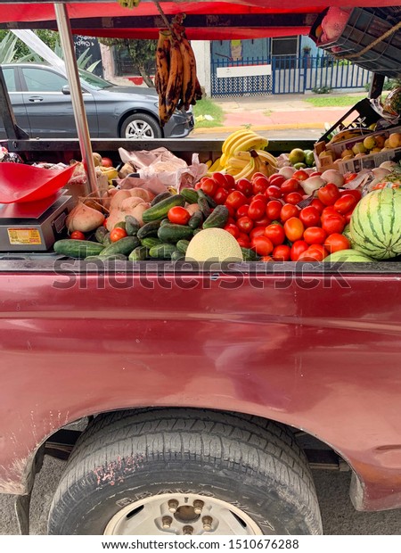 Guadalajara, Mexico - Septiembre 20 2019: Market on\
wheels. Fruit and vegetables for sale on the back of a red pick up\
truck  