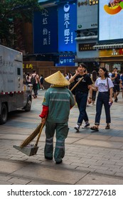 GUANGZHOU, CHINA, 18 NOVEMBER 2019: Street Cleaner With Traditional Hat In Guangzhou Downtown