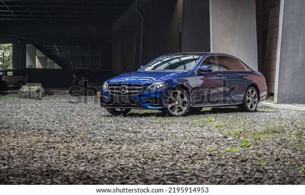 Guangzhou, China- August 18,2022: A\
\
blue Mercedes-Benz E300 L sedan is parked in\
courtyard