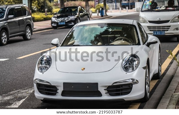 Guangzhou, China- August 18,2022: a\
white Porsche 911 Carrera S sportcar is parked in\
street