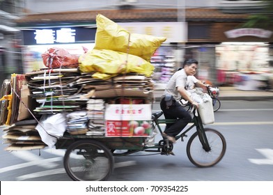 Guangzhou, China - Sept 2017: Overloaded delivery bike stacked with carton boxes and books. 