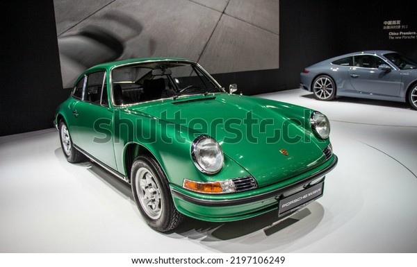 Guangzhou, China- September 1,2022: a\
green and a grey Porsche sportcars are parked in\
showroom