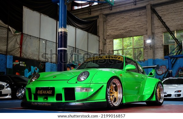 Guangzhou, China- September 1,2022: A\
green RAUH-WELT RWB Porsche sportcar is parked in\
workshop