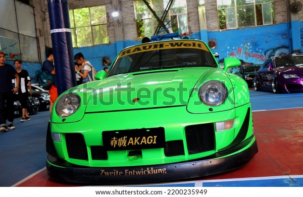 Guangzhou, China- September 1,2022: A\
green RAUH-WELT RWB Porsche sportcar is parked in\
workshop