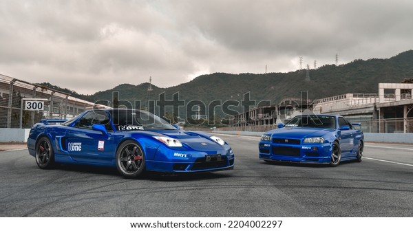 Guangzhou, China- September\
18,2022: A blue HONDA NSX and a NISSAN GTR R34 sportcars are parked\
on road
