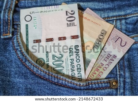 Guarani banknotes in the pocket of his jeans. Guarani is the currency of Paraguay, savings and savings concept.