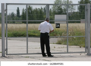 The Guard Locks The Gates Of The Guarded Facility With A Lock.
