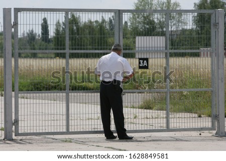 The guard locks the gates of the guarded facility with a lock.
