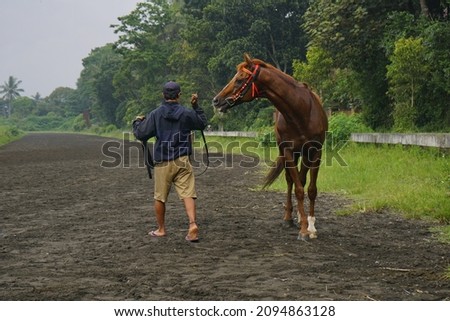 A guard was pulling his horse when he finished walking around together. This photo was taken in the Tegalwaton area, Salatiga, Central Java.