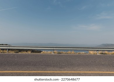 The guard rail, barrier on wayside with cloudy and hill. the straight line from highway fence. image from background, highway fence	