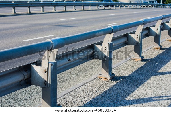 Guard\
rail metal barriers on the side of the asphalt\
road