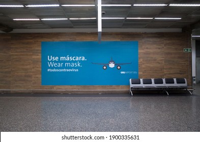 Guarulhos, São Paulo, Brazil - December 12 2020: Wear Mask Blue Sign On Wall Of São Paulo Guarulhos International Airport Due To The New Coronavirus Covid-19 Pandemic.