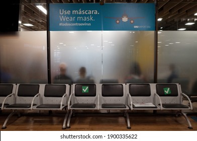 Guarulhos, São Paulo, Brazil - January 11 2021: Wear Mask Blue Sign Above Seats Of São Paulo Guarulhos International Airport Due To The New Coronavirus Covid-19 Pandemic.