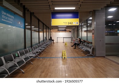 Guarulhos, São Paulo, Brazil - January 11 2021: People Seated At Empty Place Of Terminal Of São Paulo Guarulhos International Airport.