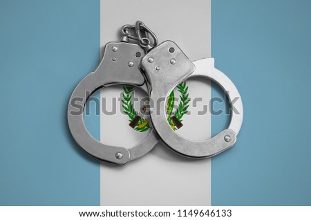 Guatemala flag  and police handcuffs. The concept of observance of the law in the country and protection from crime