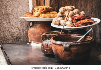 Guatemalan street food prepared in clay pots on the street in Antigua Guatemala.