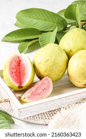 Guava Is Served With Slice On Wooden Tray. On Light Wooden Background With Copy Space. Shinny Texture, Blurry Background 