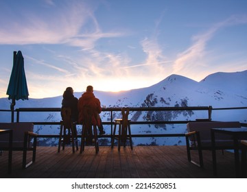 Gudauri, Georgia - 14th february, 2022: Couple together sit enjoy sunset in winter ski resort with snowy peaks background. Valentines day in winter concept. Togetherness connection concept - Shutterstock ID 2214520851