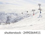 Gudauri Ski Resort: Gondola (Ski Lift) and Snow-covered Caucasus Mountains in Distance - Gudauri, Georgia.