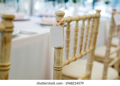 Guest Nametag Hanging On A Side Of The Wooden Vintage Chair Placed Next To A Dining Table