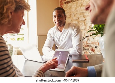 Guests Checking In At A Hotel Using A Tablet Computer