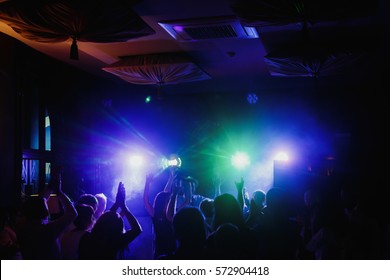 Guests Dancing At Luxury Wedding Reception In Restaurant With Live Music Live Band And Cool Motion Light. Silhouettes Of People Hands Having Fun At Crazy Party Festival. Joyful Moments