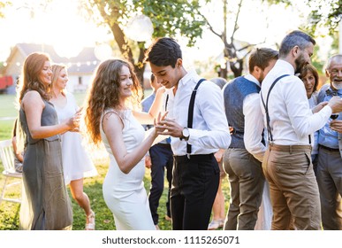 Guests Dancing At Wedding Reception Outside In The Backyard.