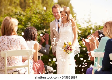 Guests Throwing Confetti Over Bride And Groom At Wedding