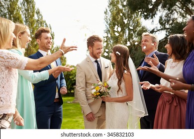 Guests Throwing Confetti Over Bride And Groom At Wedding