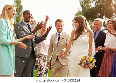 Guests Throwing Confetti Over Bride And Groom At Wedding