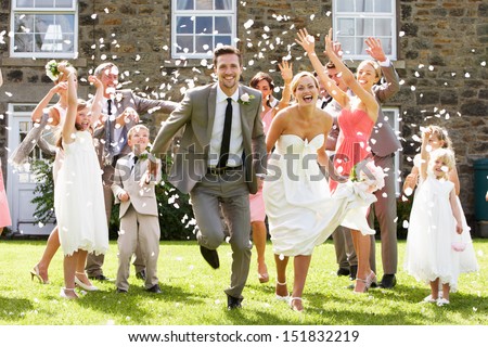 Guests Throwing Confetti Over Bride And Groom