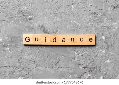 Guidance word written on wood block. Guidance text on table, concept.