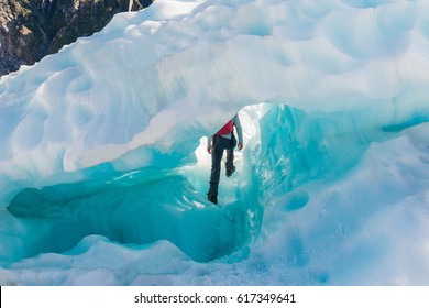 Guide To Break The Glaciers, Walking Through Glacier Tunnel With Guide Using Ice Pick. Fox Glacier, New Zealand. 