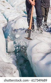 Guide To Break The Glaciers, Walking Through Glacier Tunnel With Guide Using Ice Pick. Fox Glacier, New Zealand. 