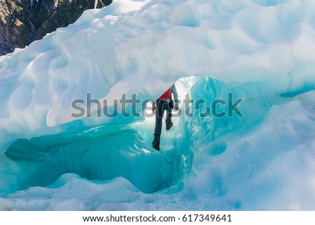 Guide to break the glaciers, Walking through glacier tunnel with guide using ice pick. Fox Glacier, New Zealand. 