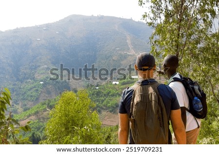 Guide pointing out something on a hike around the town of Kibuye, by Lake Kivu, Rwanda.
