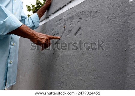 A guide showing and explaining the reason of scratches on the coral rock wall at Male Friday Mosque Complex, Maldives.