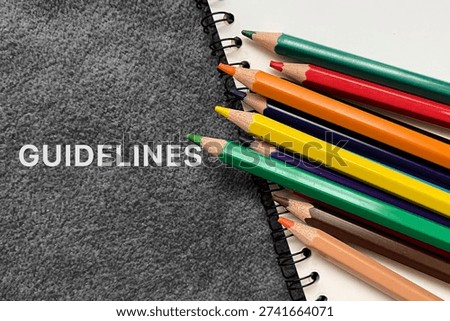 Guidelines text on notebook with colorful pencils, education and corporate policy concept.