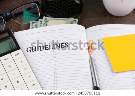 Guidelines written in the manager's notebook in a composition with dollars, a calculator, a pen, stickers, glasses, paper clips